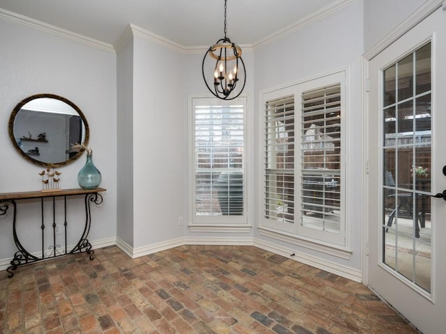 unfurnished dining area featuring a notable chandelier, brick floor, a wealth of natural light, and crown molding