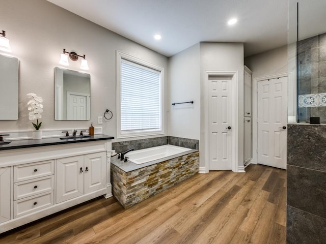 full bath featuring a garden tub, recessed lighting, wood finished floors, vanity, and a walk in shower