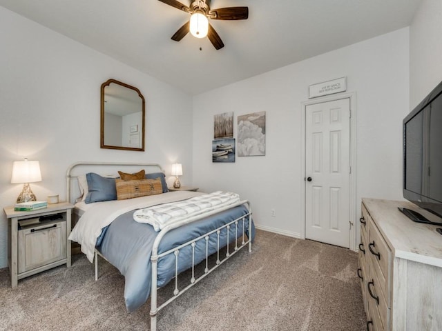 carpeted bedroom with ceiling fan and baseboards