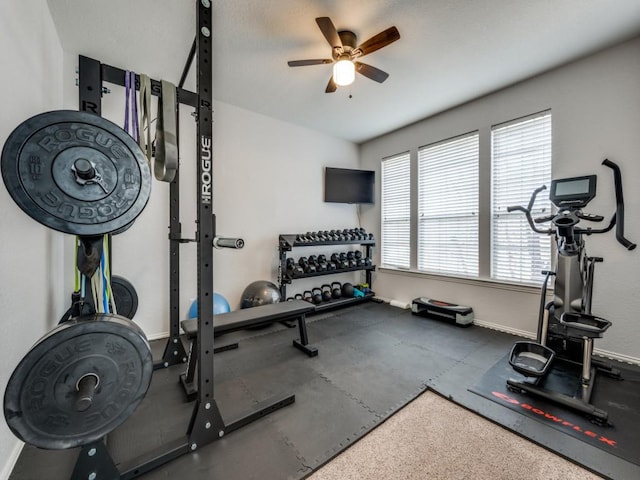 workout area featuring a ceiling fan and baseboards