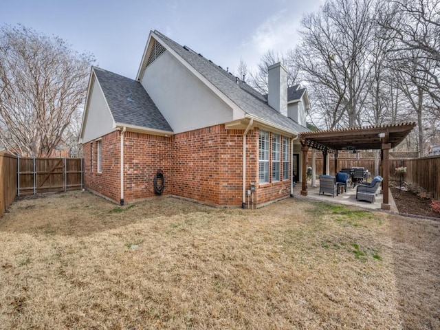 rear view of house with a fenced backyard, brick siding, a pergola, a chimney, and a patio area