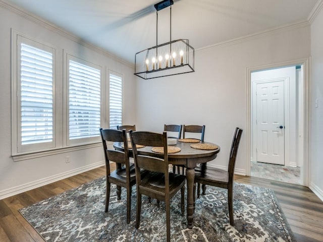 dining area with an inviting chandelier, baseboards, ornamental molding, and wood finished floors