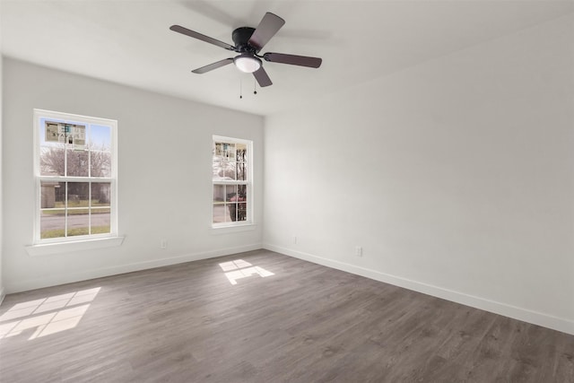 spare room featuring ceiling fan, baseboards, and wood finished floors