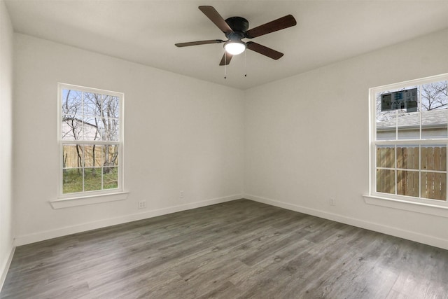 empty room featuring a ceiling fan, baseboards, and wood finished floors