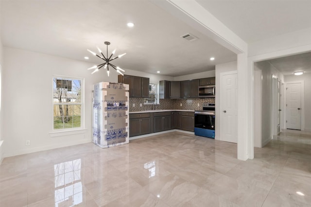 kitchen with visible vents, decorative backsplash, appliances with stainless steel finishes, dark brown cabinets, and a notable chandelier