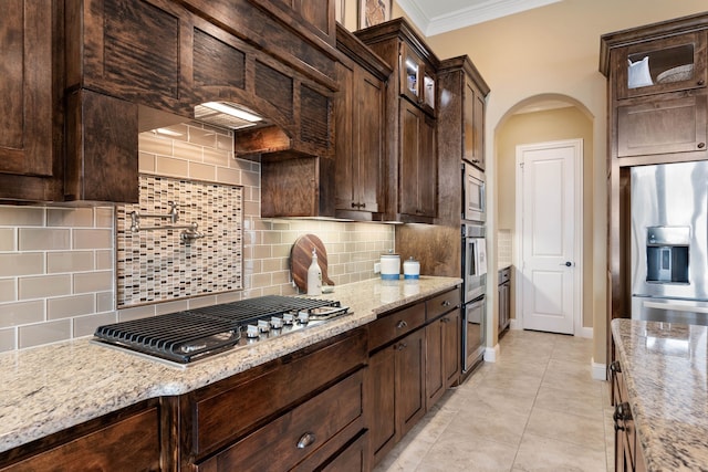 kitchen with dark brown cabinets, appliances with stainless steel finishes, glass insert cabinets, and crown molding