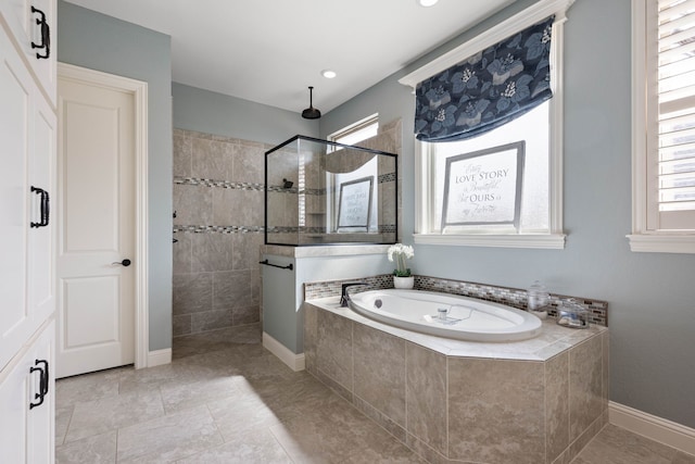 bathroom with a garden tub, baseboards, and a walk in shower