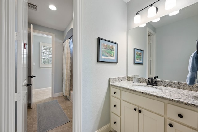 full bath featuring curtained shower, visible vents, vanity, and baseboards