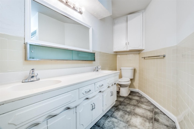 full bath featuring a sink, tile walls, toilet, and double vanity