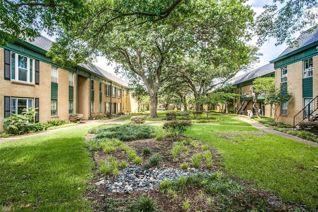 view of grassy yard with stairs