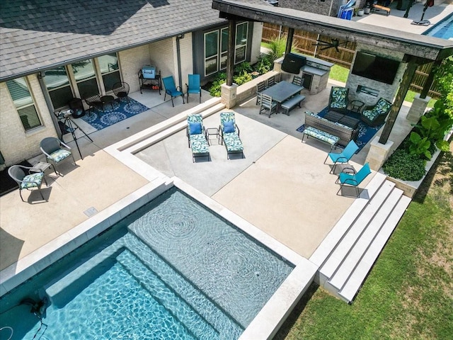 view of pool with a patio and an outdoor living space with a fireplace