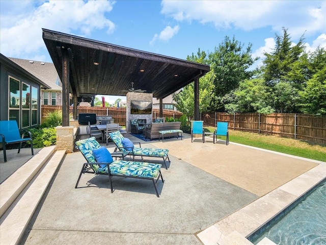 view of patio / terrace featuring an outdoor living space with a fireplace, a fenced backyard, and ceiling fan