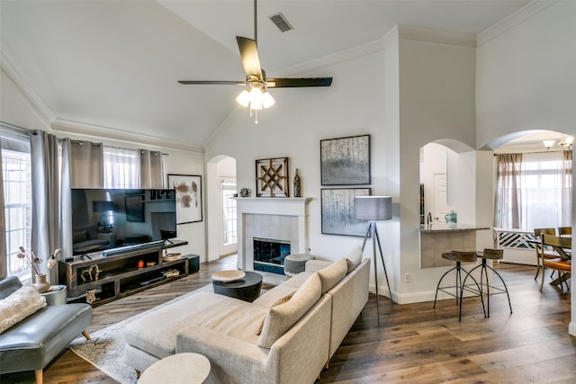 living area with visible vents, arched walkways, and crown molding