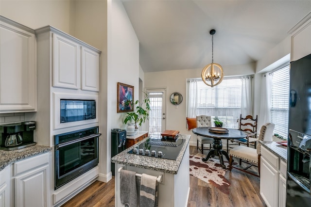 kitchen with a chandelier, dark wood-style flooring, vaulted ceiling, black appliances, and white cabinetry