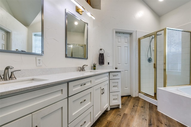 full bath with a bath, a stall shower, a sink, and wood finished floors