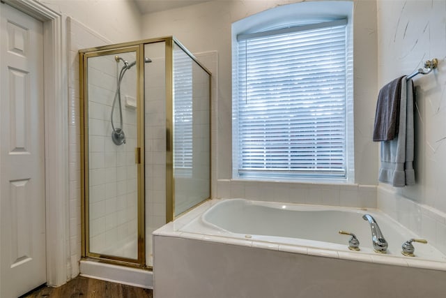 full bath with a stall shower and a garden tub