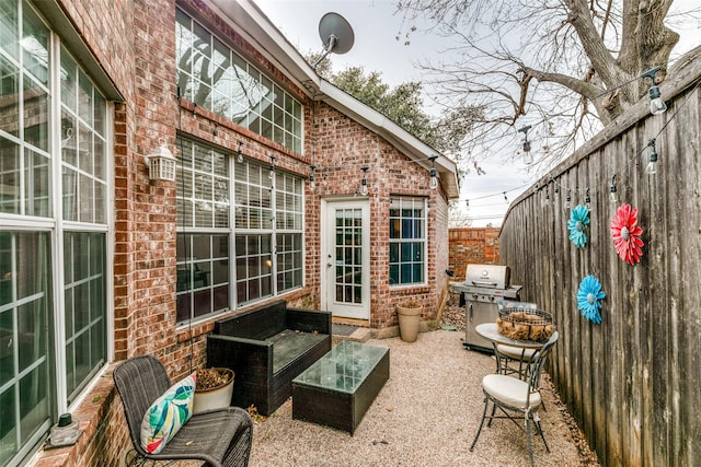 view of patio with a grill and fence