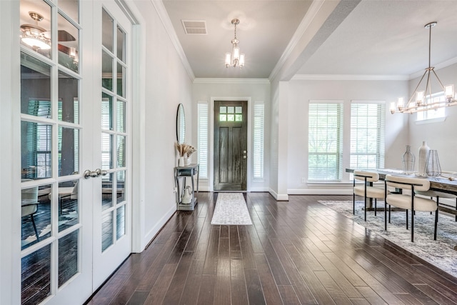 entrance foyer with a chandelier, dark wood-type flooring, visible vents, baseboards, and plenty of natural light
