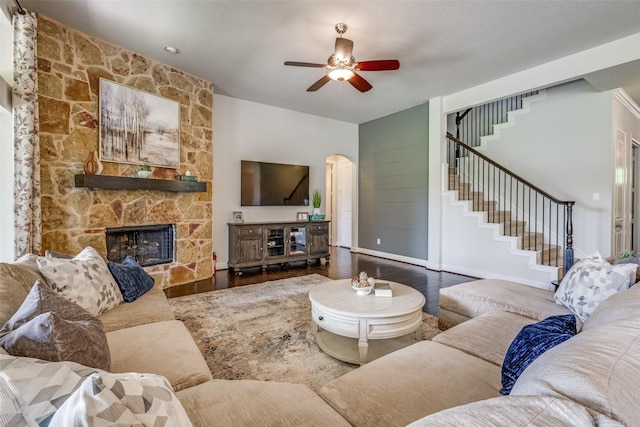 living room featuring stairs, visible vents, a ceiling fan, and dark wood finished floors