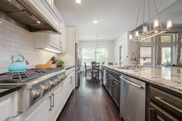 kitchen with white cabinetry, a sink, appliances with stainless steel finishes, visible vents, and light stone countertops