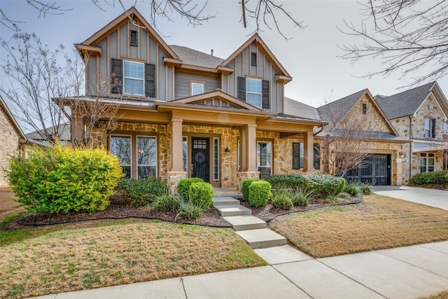 craftsman inspired home featuring board and batten siding, cooling unit, stone siding, and driveway