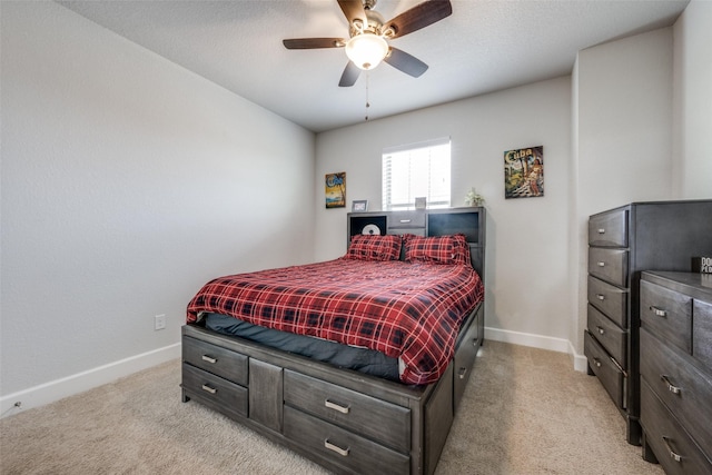 bedroom featuring a ceiling fan, light colored carpet, and baseboards