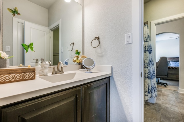 bathroom with a textured wall and vanity