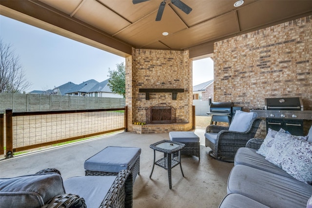 view of patio with a fenced backyard, ceiling fan, an outdoor living space with a fireplace, and area for grilling