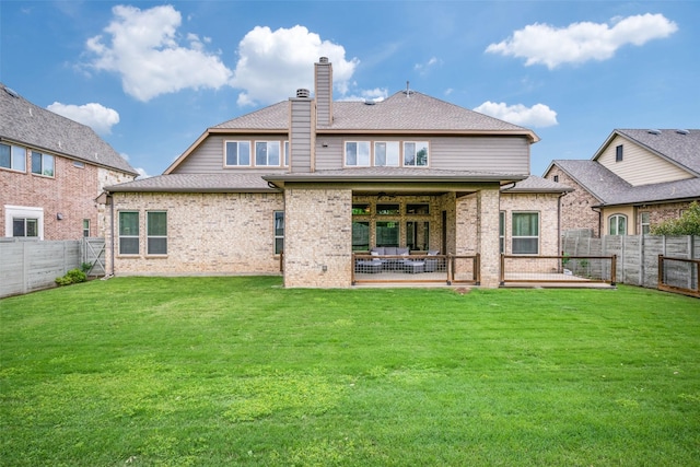 back of property with a patio, a chimney, a lawn, brick siding, and a fenced backyard