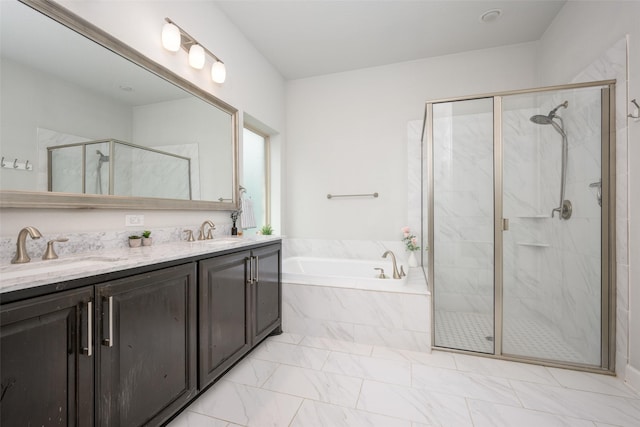 full bathroom with a stall shower, marble finish floor, a garden tub, and a sink