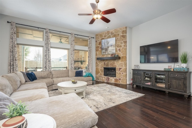 living area featuring ceiling fan, a fireplace, and wood finished floors