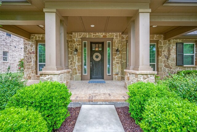 entrance to property with stone siding and covered porch