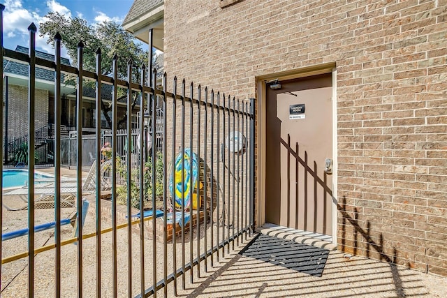 entrance to property with brick siding and fence