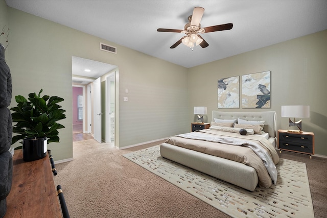 carpeted bedroom featuring ceiling fan, visible vents, and baseboards