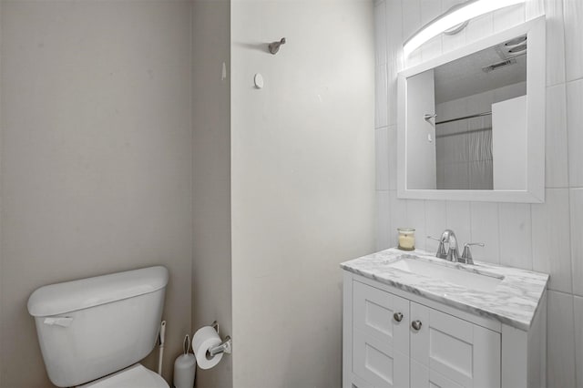 full bathroom featuring toilet, visible vents, and vanity