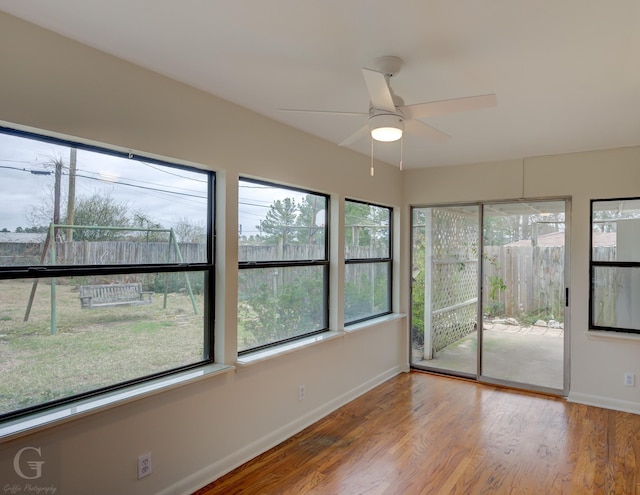 unfurnished sunroom featuring a ceiling fan