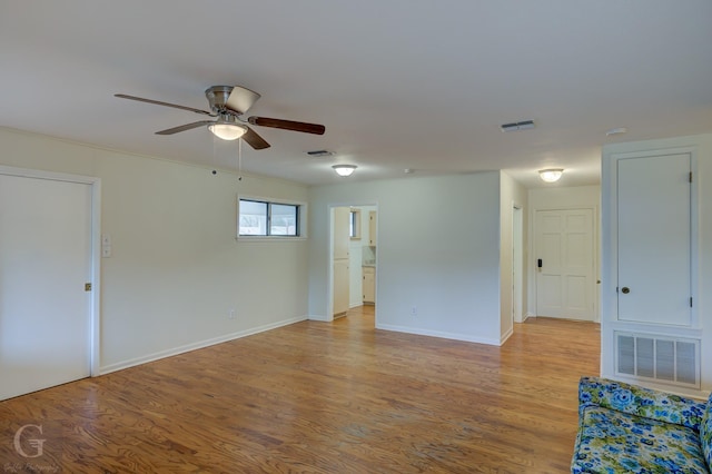 empty room with light wood-type flooring, visible vents, and baseboards