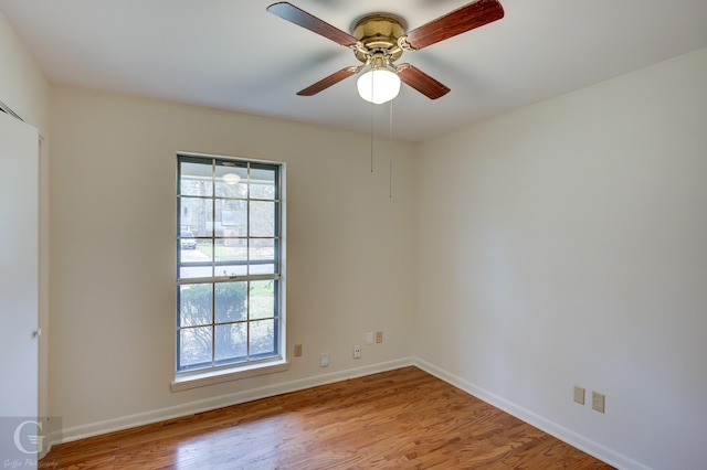 unfurnished room featuring light wood finished floors, baseboards, and a ceiling fan