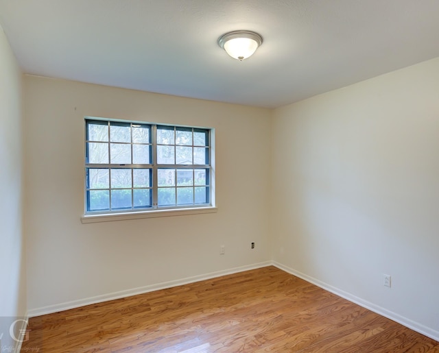 unfurnished room with light wood-type flooring and baseboards