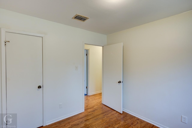 unfurnished bedroom featuring baseboards, visible vents, and light wood finished floors