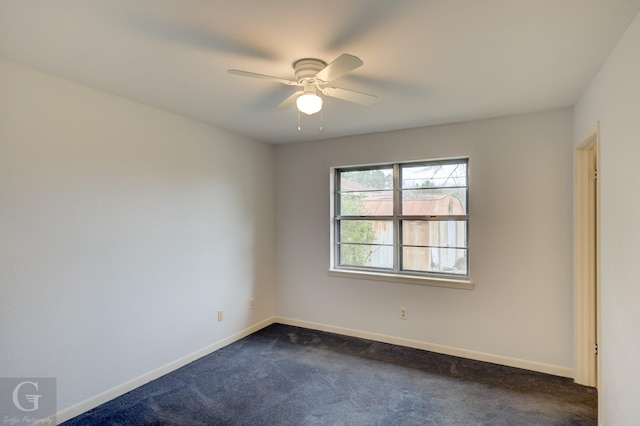 unfurnished room featuring baseboards, dark carpet, and a ceiling fan