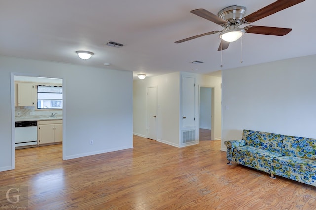 living room with light wood-style floors, baseboards, and visible vents