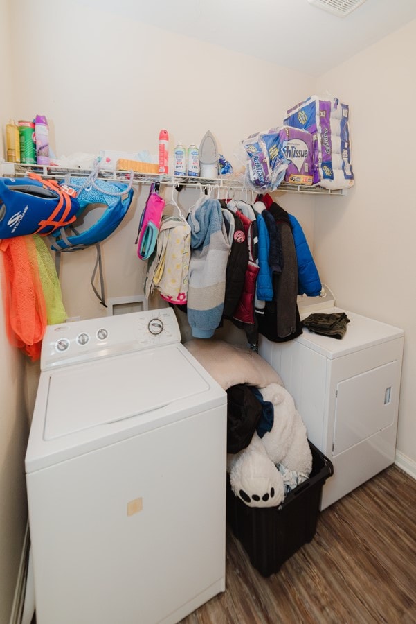 laundry area featuring laundry area, wood finished floors, washer / dryer, and baseboards