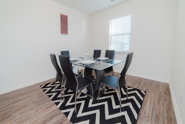 dining space featuring baseboards and wood finished floors