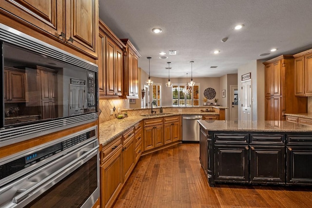 209 Chrissa Dr, Pottsboro, TX 75076 - kitchen featuring stainless steel appliances, a sink, a peninsula, decorative light fixtures, and recessed lighting