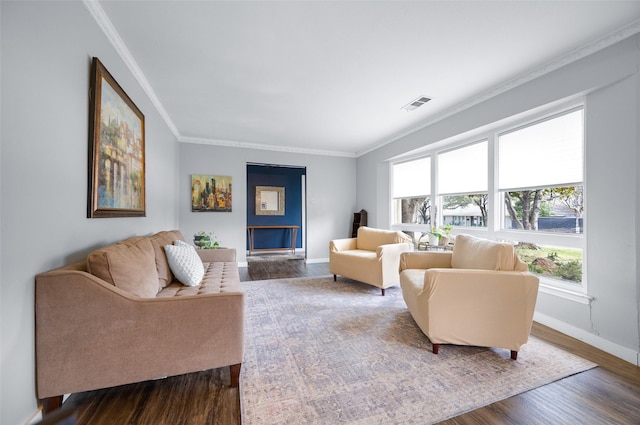 living room featuring dark wood-type flooring, visible vents, ornamental molding, and baseboards