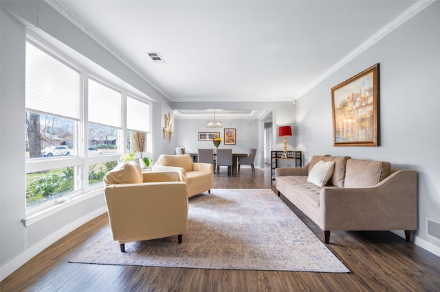 living area with baseboards, visible vents, a chandelier, and ornamental molding