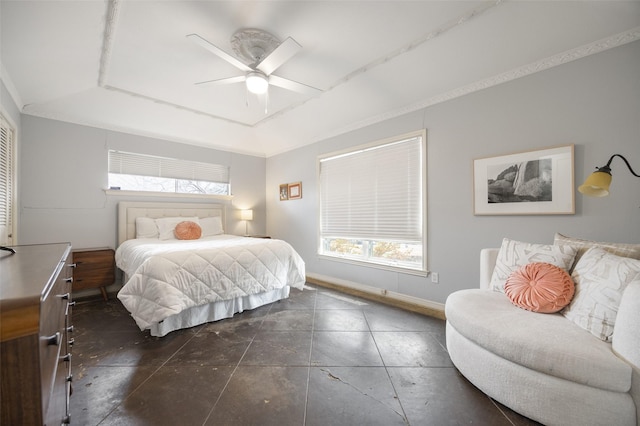 bedroom with baseboards, a tray ceiling, and a ceiling fan