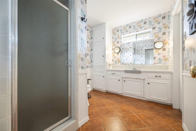 bathroom with a shower stall, vanity, and wallpapered walls