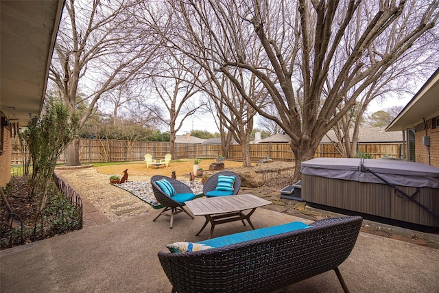 view of patio / terrace with a hot tub, a fire pit, and a fenced backyard